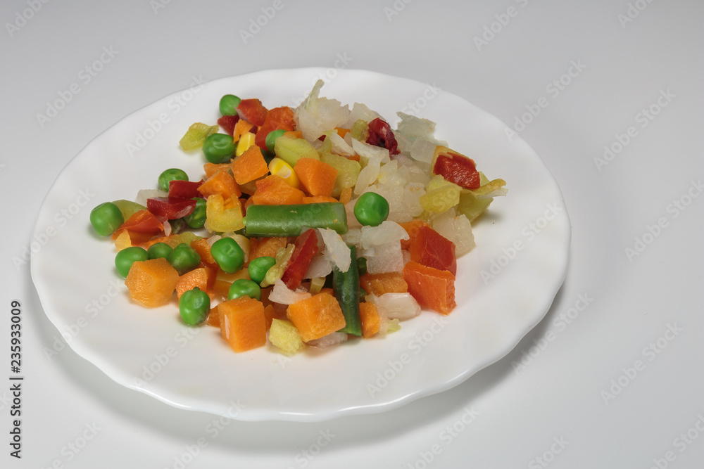 Boiled mix of vegetables, as the concept of diet. Vegan food - vegetables for breakfast. White background. Boiled mix of vegetables, as the concept of diet. Vegan food - vegetables for breakfast. White background.