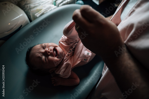 Father changing newborn's clothes