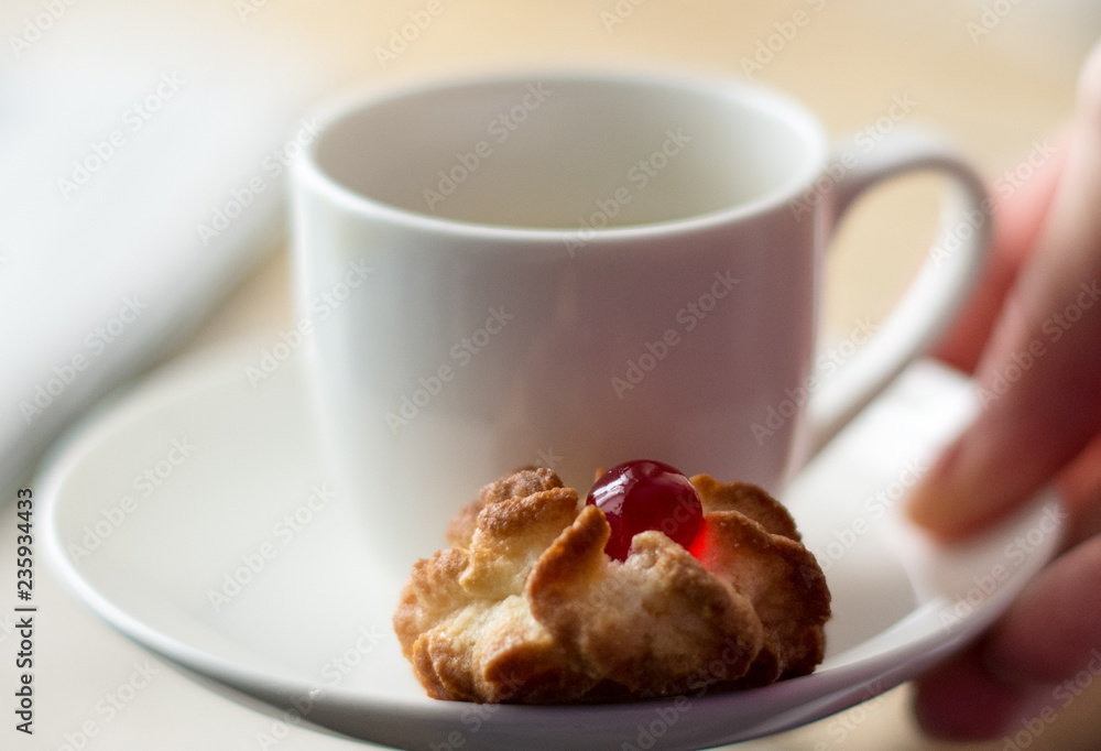 Porcelain white pot with little pastry on the saucer Porcelain white pot with little pastry on the saucer