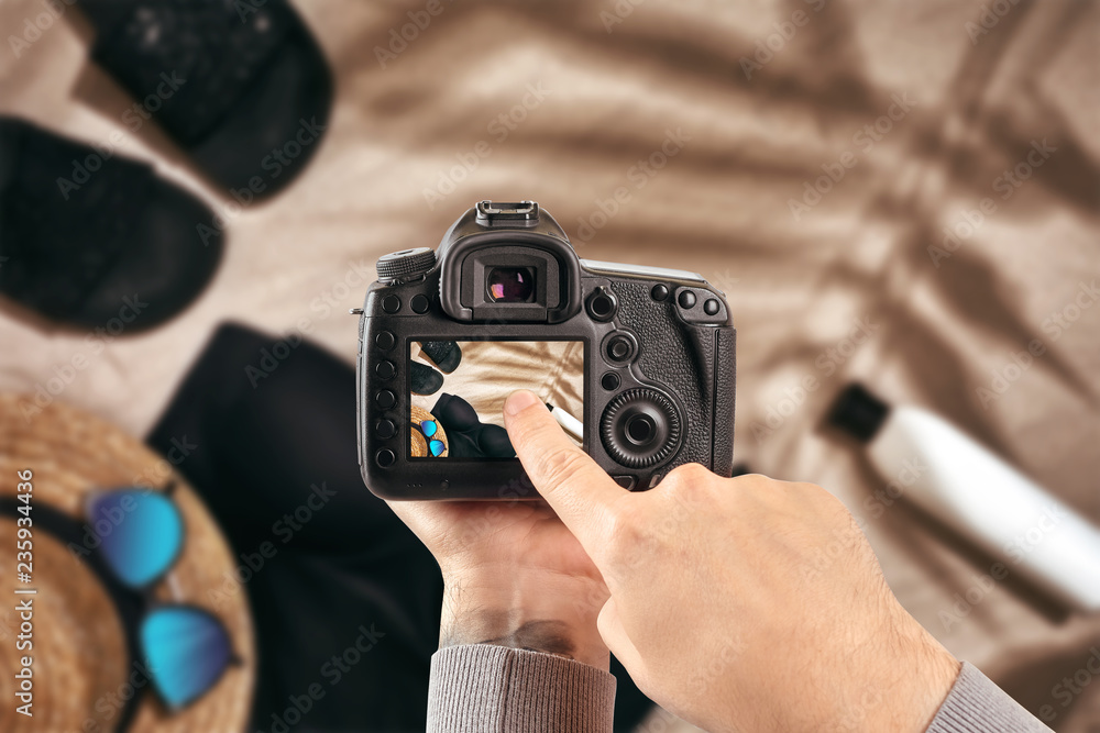 Digital single-lens reflex camera in hands. Man photographer makes photos. Male hands hold the camera close-up Digital single-lens reflex camera in hands. Man photographer makes photos. Male hands hold the camera close-up