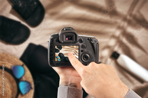 Digital single-lens reflex camera in hands. Man photographer makes photos. Male hands hold the camera close-up