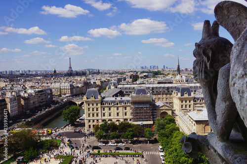 Notre Dame of Paris: The Stryge (most famous of the Chimeres) overlooking the skyline of Paris at a summer day