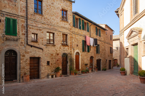 Old street of medieval town Pienza are decorated with flowers in the flowerpots  Italy