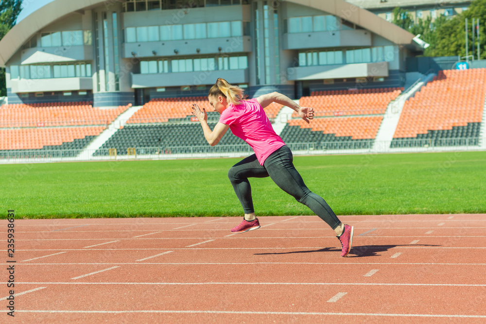 A young girl in the stadium runs.