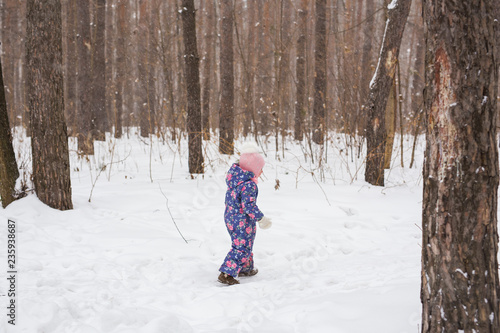Family, children and nature concept - Beautiful little child girl have fun in winter park