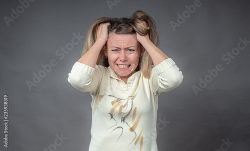 Woman in stress. Girl gritted her teeth in hysterical angry emotion, isolated on gray. Portrait of woman in despair and panic. Negative human emotion on face expression, conflict confrontation.