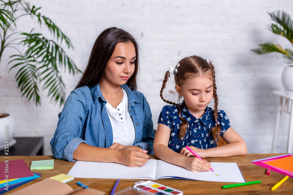 Happy family mother and daughter together draw with markers. Happy family mother and daughter together draw with markers.