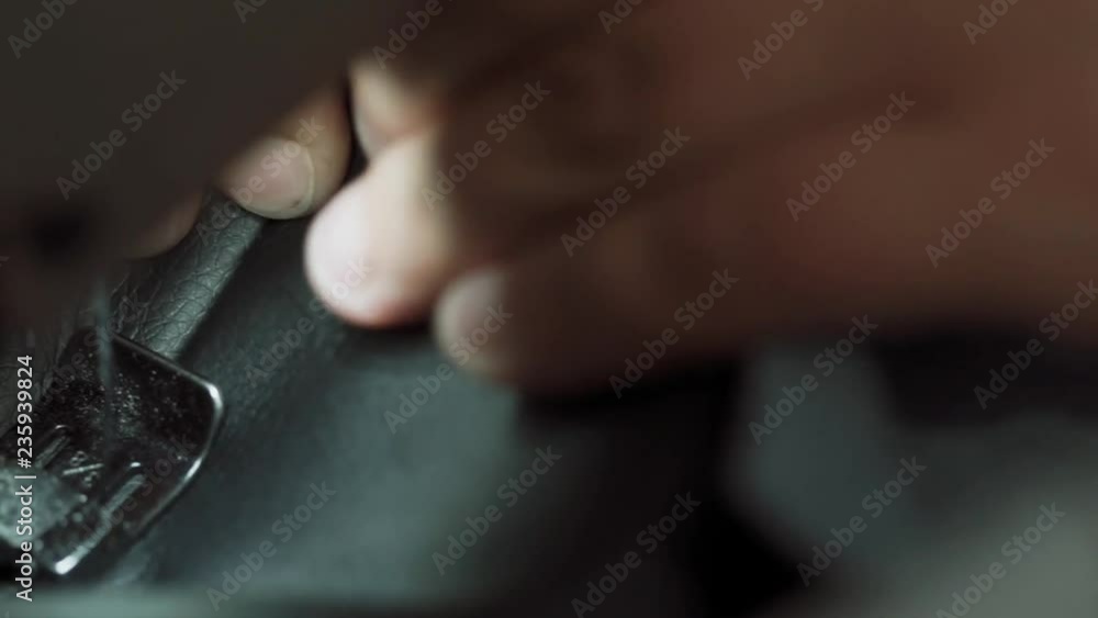 close-up of the hand of a seamstress and the needle of a sewing machine making a line in leather close-up of the hand of a seamstress and the needle of a sewing machine making a line in leather