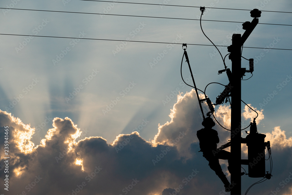 Silhouette, power lineman use clamp stick (insulated tool) to closing a