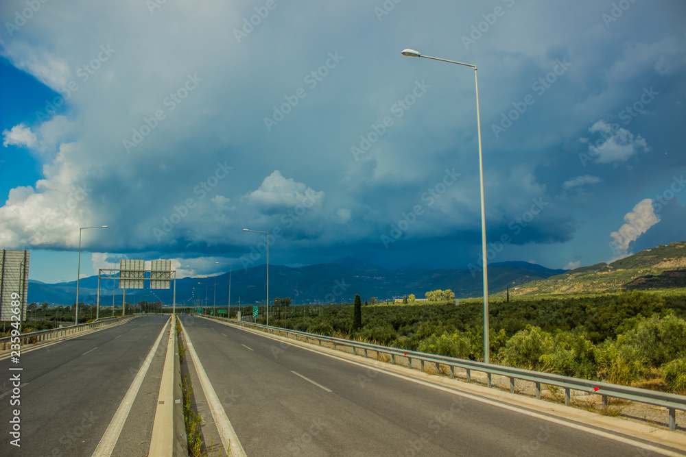 empty highway car road in gray rainy weather time before storm in beautiful nature landscape environment with mountains horizon background 