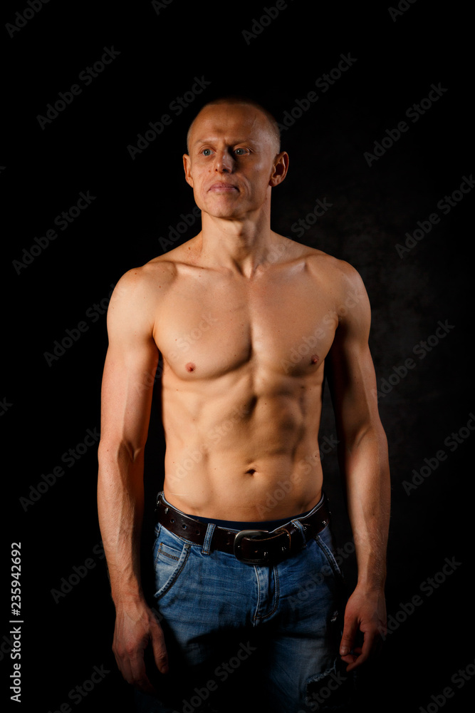 Fototapeta premium Handsome and muscular man in dark background
