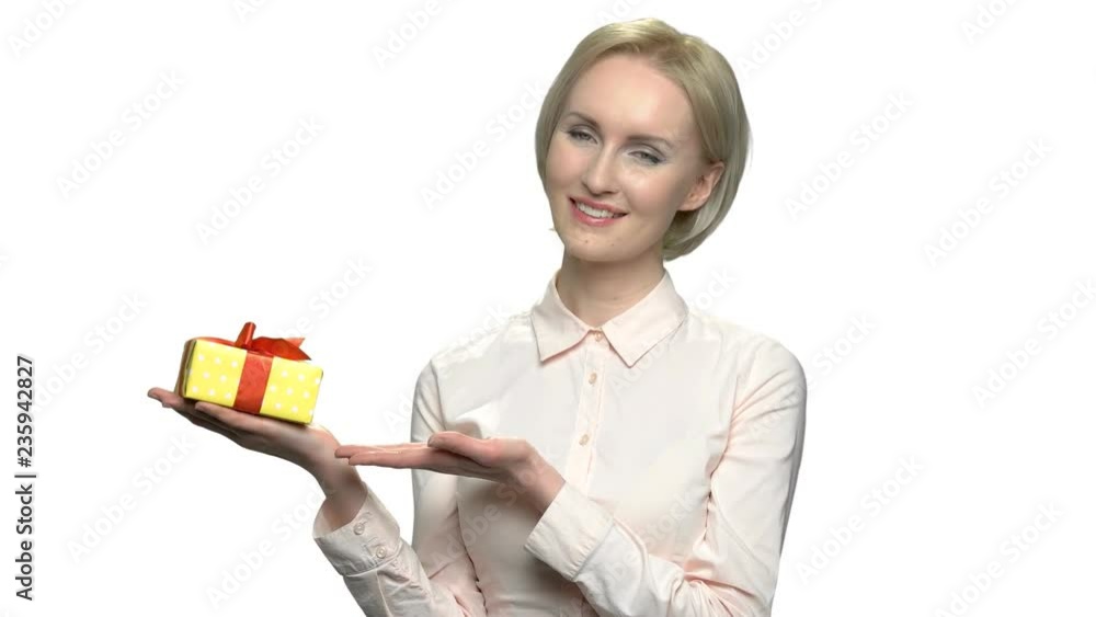 Pretty blonde with gift box on her palm. Beautiful caucasian business woman posing with gift box. Special offer for you. Holiday celebration concept.