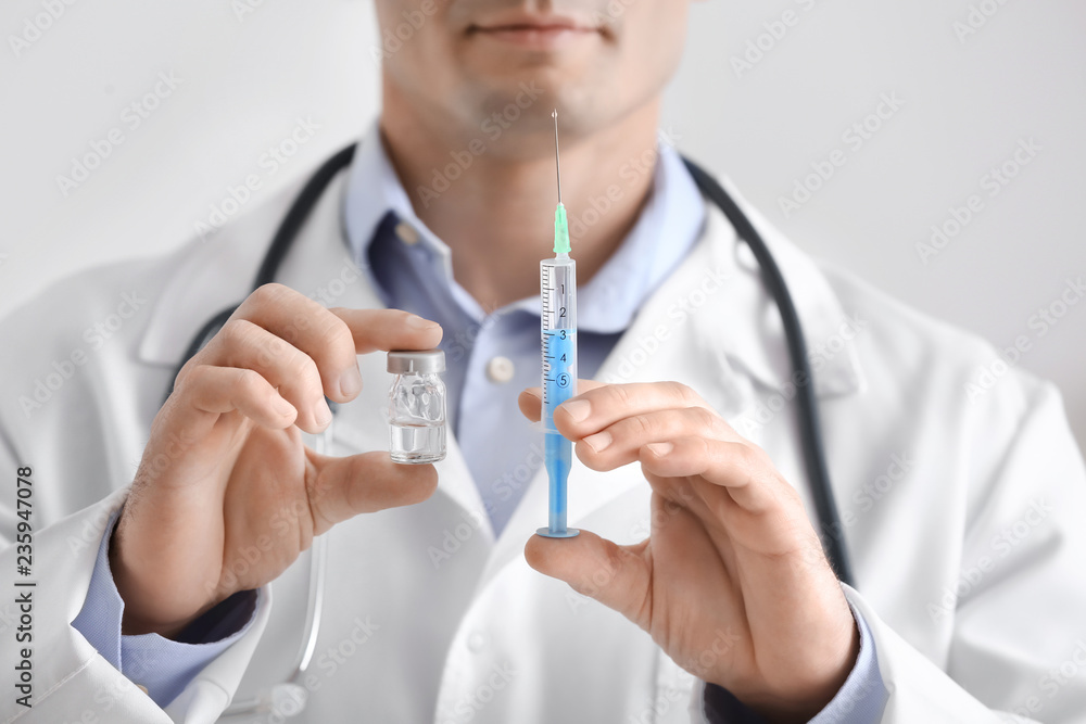 Doctor with syringe and vial, closeup. Vaccination day Doctor with syringe and vial, closeup. Vaccination day
