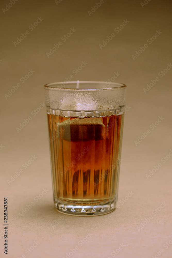 Glass with black tea on a brown background Glass with black tea on a brown background