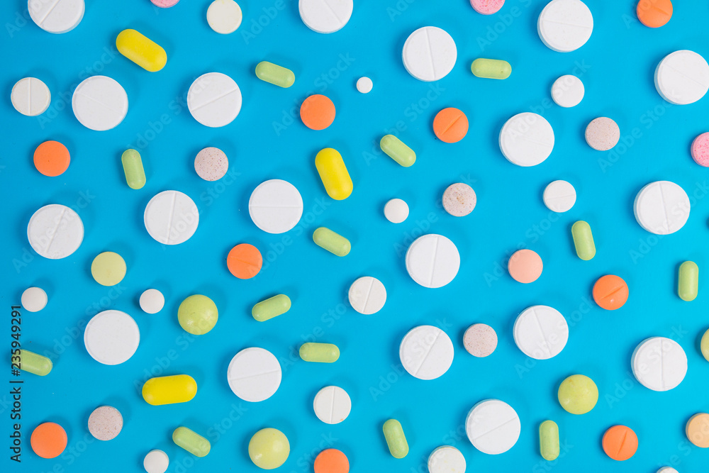 Medical pills and antibiotics on blue background.