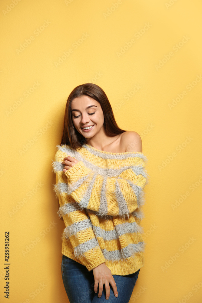 Beautiful young woman in warm sweater on color background Beautiful young woman in warm sweater on color background