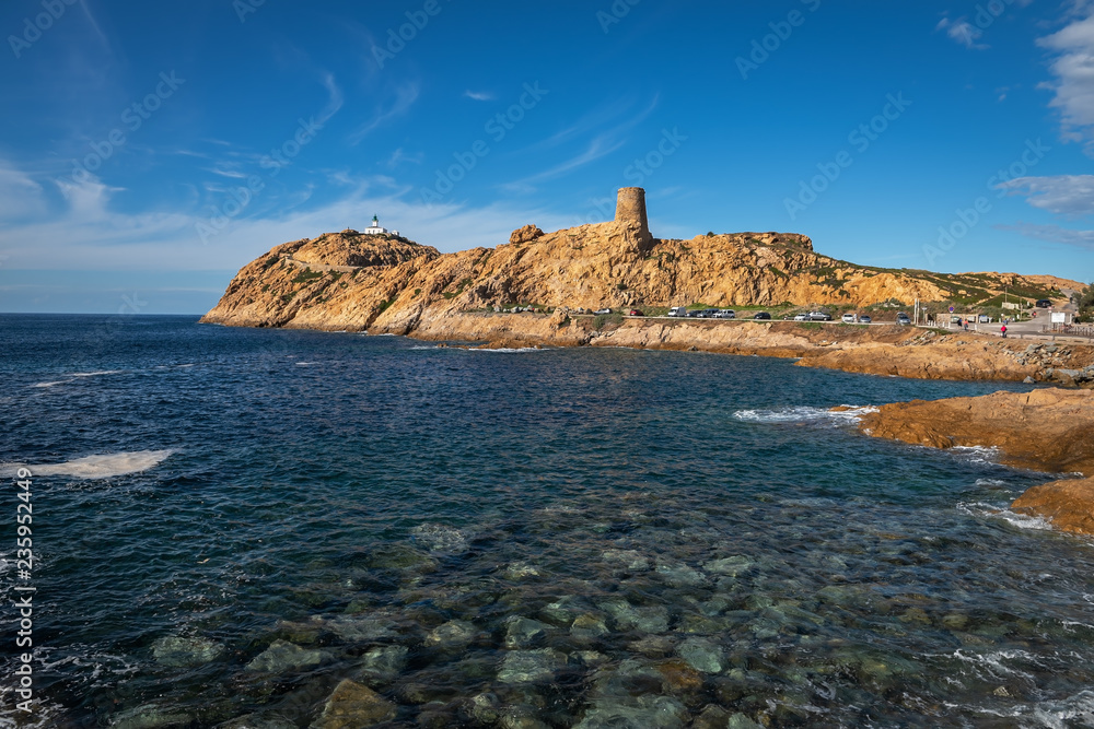 View from the shore to the Genoese tower and the lighthouse in L'Ile-Rousse, Corsica, France View from the shore to the Genoese tower and the lighthouse in L'Ile-Rousse, Corsica, France