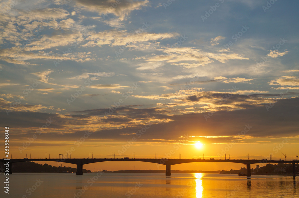Beautiful orange sunset over the bridge on the Volga river in Kostroma