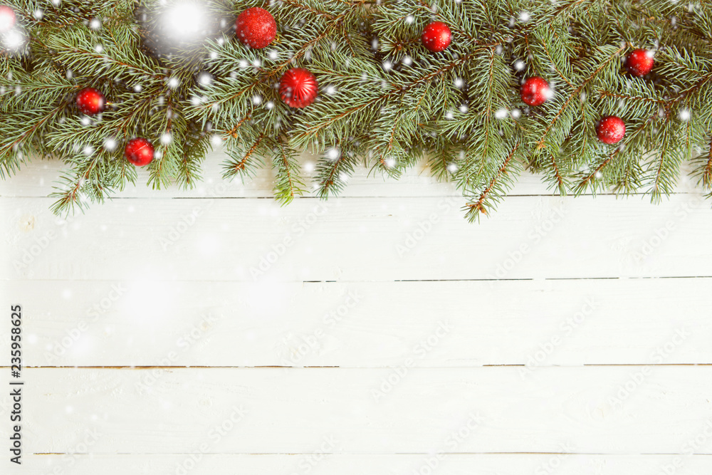 Christmas and New Year background. Fir tree branches with red christmas balls on white wooden bacground Christmas and New Year background. Fir tree branches with red christmas balls on white wooden bacground