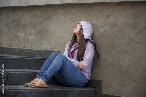 Asian Korean student woman or bullied teenager girl sitting outdoors on street staircase victim of bullying feeling scared and stressed suffering depression problem © TheVisualsYouNeed