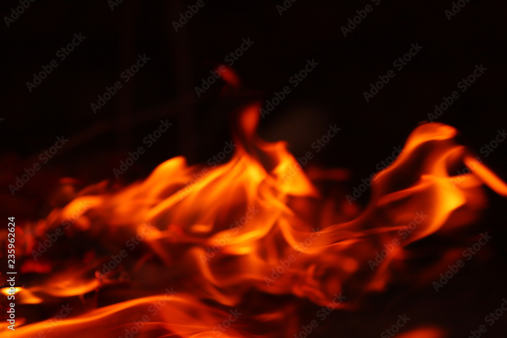 Abstract background image of a red flame of a fire. Orange and red flames on a dark background. Cropped shot, close-up, blurred Abstract background image of a red flame of a fire. Orange and red flames on a dark background. Cropped shot, close-up, blurred