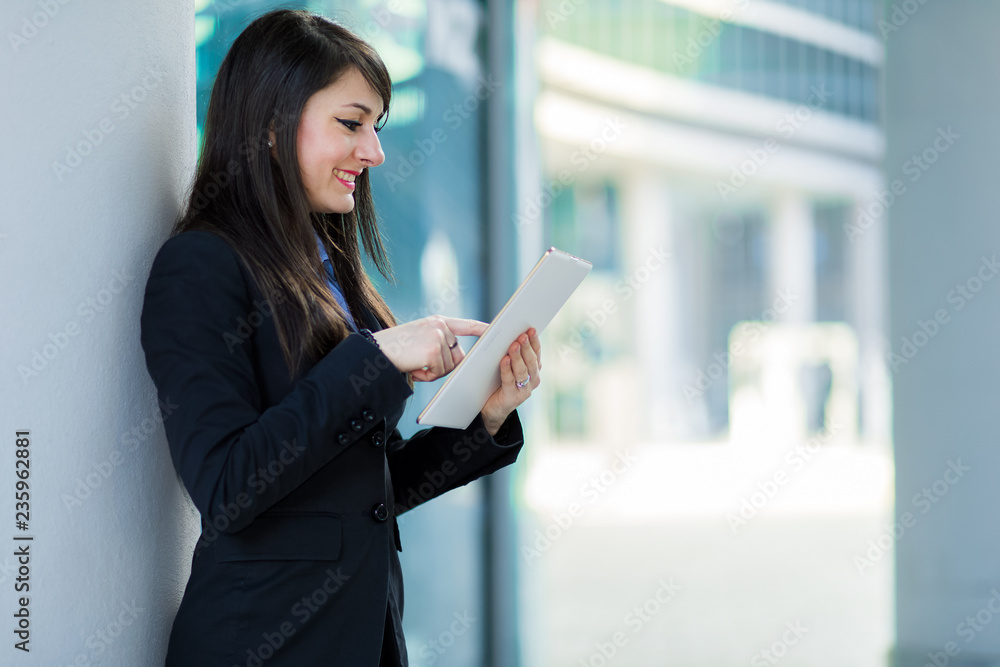 Smiling businesswoman using a digital tablet outdoor Smiling businesswoman using a digital tablet outdoor