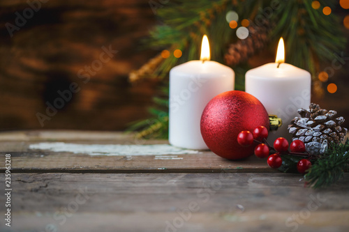 Christmas decorations  burning candles  spruce on a wooden background. New Year s concept. Postcard