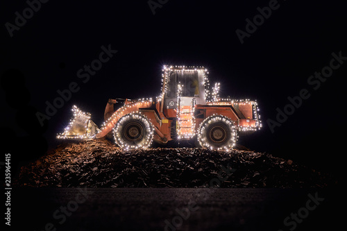 Blurred wheel loader decorated with lights in winter