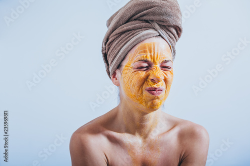 Young woman with an egg mask on her face