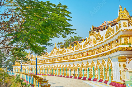 Distinctive colonnade of U Min Thonze Temple with rich gilt patterns and numerous images of Lord Buddha, located in niches, Sagaing, Myanmar. photo