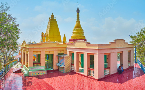 SAGAING, MYANMAR - FEBRUARY 21, 2018: Panorama of the pagoda of U Min Thonze Caves site with covered pavilions and golden stupa, decorated with carved patterns, on February 21 in Sagaing photo