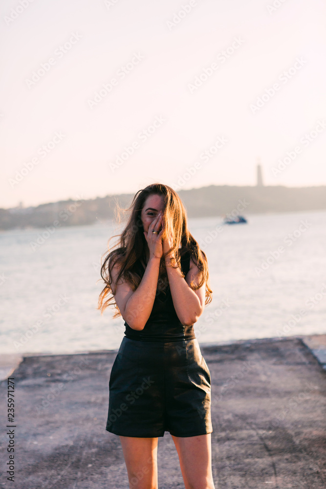 Smiling young woman in casual wear near water with boats Smiling young woman in casual wear near water with boats