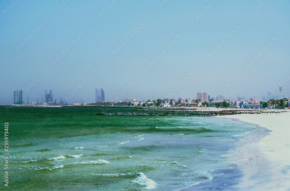 The Shore Of The Arabian Gulf. The Emirate Of Ajman. Beautiful sea landscape with waves and white sand.