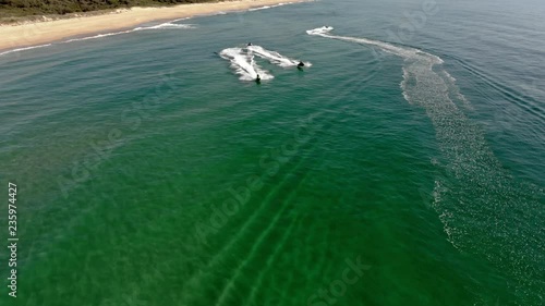 Stunning drone footage capturing three jet skis as they take off out to sea photo