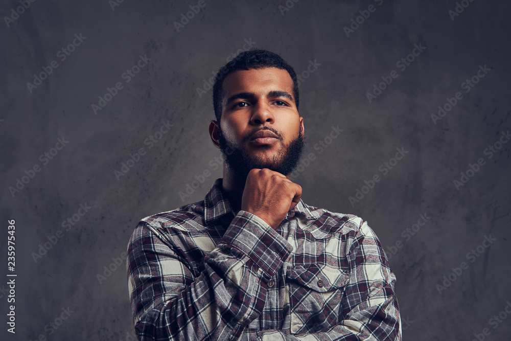 Portrait of a pensive African-American guy with a beard wearing a checkered shirt Portrait of a pensive African-American guy with a beard wearing a checkered shirt