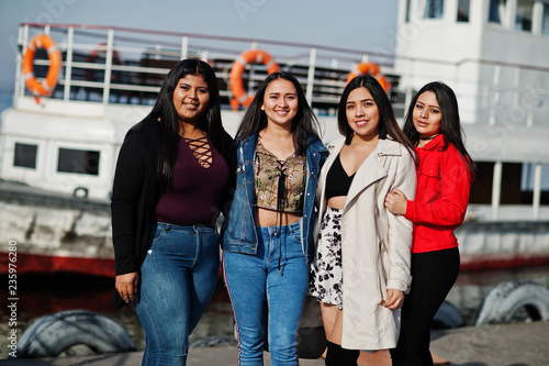 Group of four happy and pretty latino girls from Ecuador posed against boat. © AS Photo Family