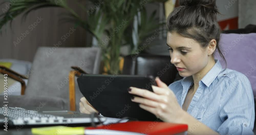 Young woman using digital tablet computer in home Young woman using digital tablet computer in home