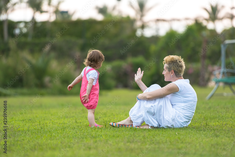 Naklejka premium mother and little daughter playing at backyard
