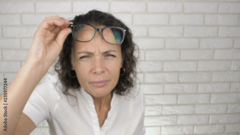 Woman takes off glasses. The concept of a visually impaired woman. Woman takes off glasses. The concept of a visually impaired woman.