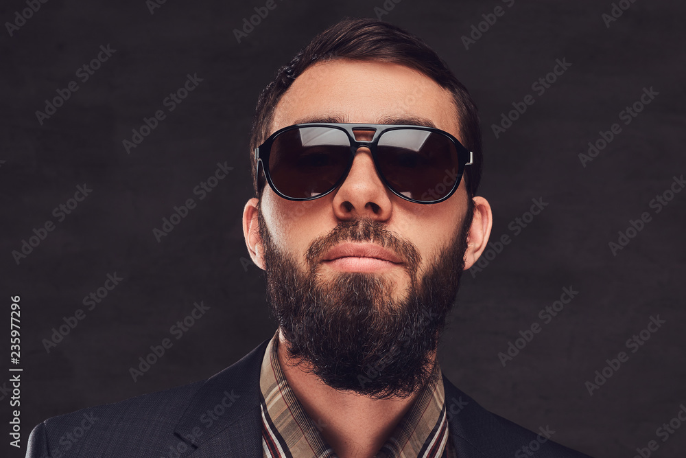 Obraz premium Close-up portrait of a bearded man wearing a suit and sunglasses.
