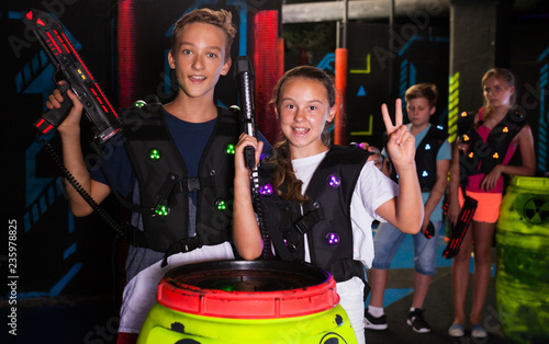 Girl and boy with laser guns on lasertag arena