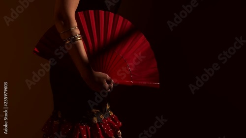 Close up woman showing one red fan open and close in traditional spanish dress photo