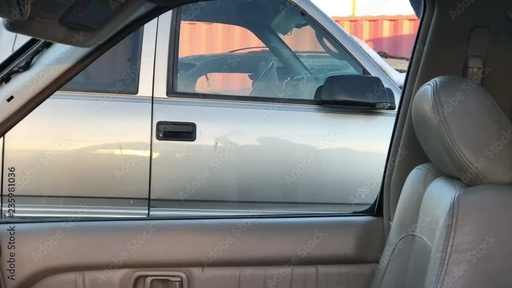 Hammer breaks glass in slow motion on luxury car before theft; in angled lighting. Hammer breaks glass in slow motion on luxury car before theft; in angled lighting.