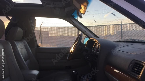 Grand theft auto clip of ski masked man breaking drivers door window before entering vehicle to pound in screwdriver and start engine.