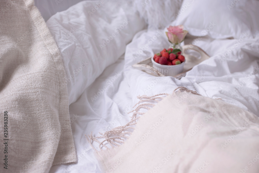 Strawberries and roses in bed in the morning. Romance and tenderness at home. Copy space.