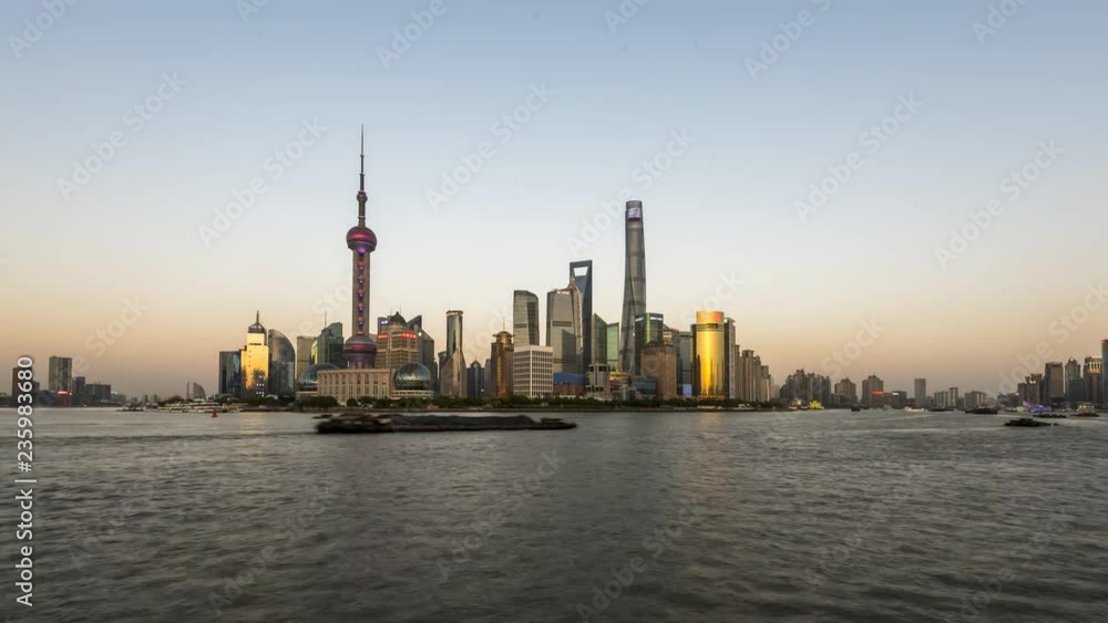 Time Lapse - Day to night - Shanghai the Bund with a view above the river and the transportation by big ships Time Lapse - Day to night - Shanghai the Bund with a view above the river and the transportation by big ships
