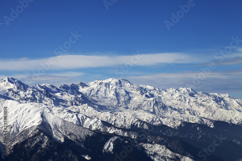Snowy mountains and blue sky with clouds in nice sunny evening © BSANI