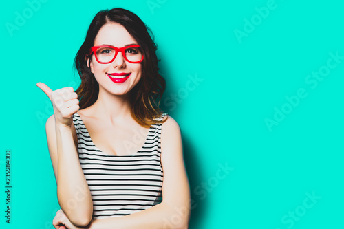 portrait of beautiful smiling young woman in glasses on the wonderful blue studio background