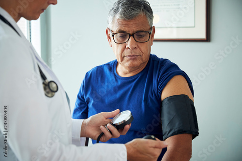 Doctor taking man's blood pressure