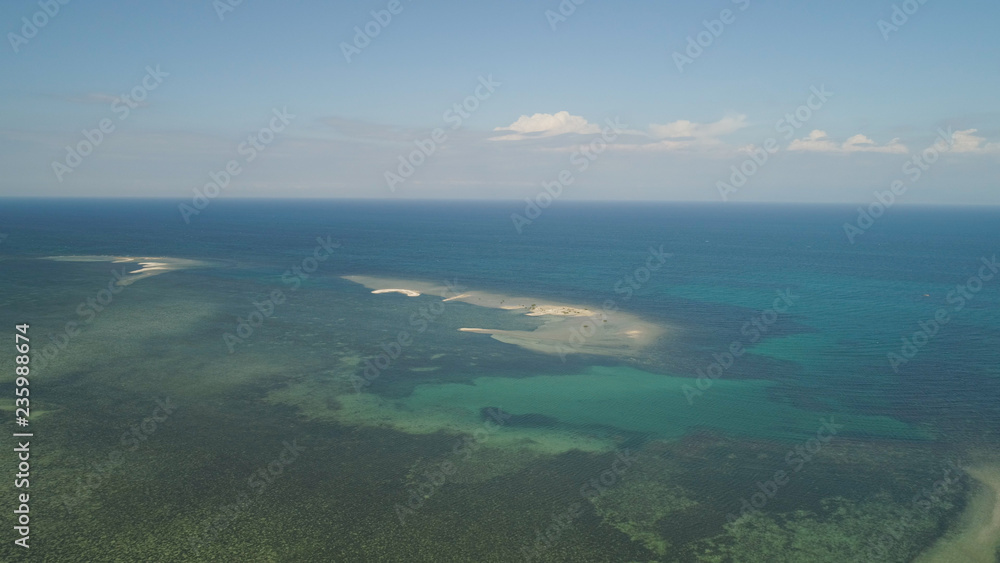 Tropical island with white sandy beach. Aerial view of sandy Cory island with colorful reef. Seascape, ocean and beautiful beach. Philippines, Anda, Pangasinan. Travel concept.